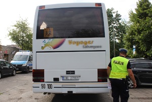 Policjant przeprowadza kontrolę autobusu, sprawdza światła