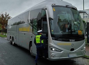 Policjant przeprowadza kontrolę autobusu, wchodzi do kabiny