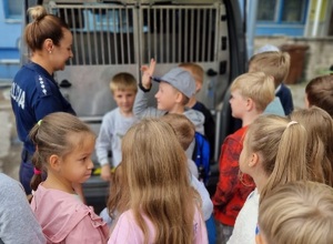 grupa dzieci stoi przy policjantce