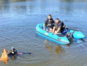 policjanci na pontonie i nurek podczas sprzątania jeziora
