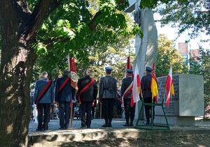 Policjanci i inni zgromadzeni podczas uroczystości pod pomnikiem