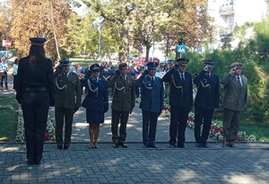 Policjanci i inni zgromadzeni podczas uroczystości pod pomnikiem