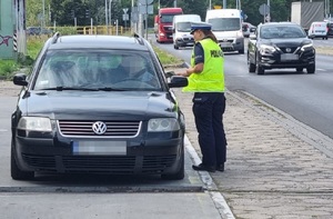 policjantka rozdaje kierowcom ulotki