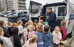 Grupa dzieci podczas spotkania z policjantami i oglądania policyjnego sprzętu