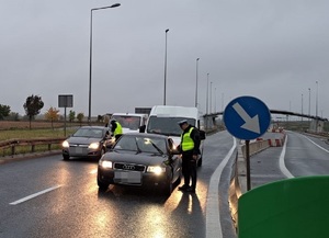 Policjanci w kamizelkach odblaskowych kontrolują na drodze trzeźwość kierowców