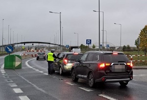 Policjanci w kamizelkach odblaskowych kontrolują na drodze trzeźwość kierowców