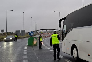 Policjanci w kamizelkach odblaskowych kontrolują na drodze trzeźwość kierowców