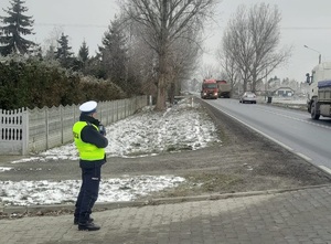 Policjant ruchu drogowego podczas kontroli prędkości poruszających się pojazdów