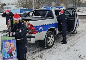 Policjanci podczas pakowania i przekazywania prezentów