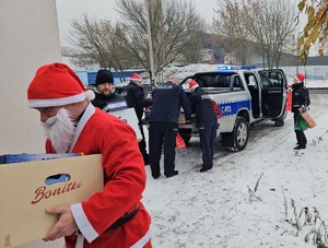 Policjanci podczas pakowania i przekazywania prezentów