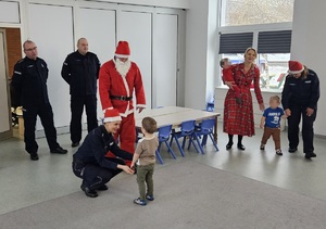 Policjanci podczas pakowania i przekazywania prezentów