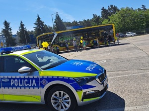 Policjanci podczas pikniku z okazji Dnia Dziecka. Widoczny policyjny radiowóz