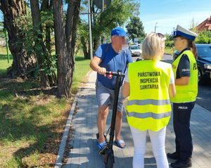 Policjanci i pracownicy sanepidu podczas wspólnych działań na drodze rozdają ulotki