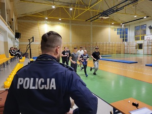 Policjanci podczas testu sprawności fizycznej na terenie szkoły