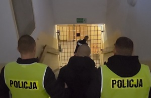 Policjanci podczas czynności związanych z doprowadzaniem zatrzymanego