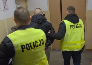 Policjanci podczas czynności związanych z doprowadzaniem zatrzymanego